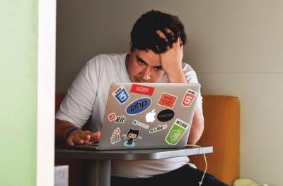 Frustrated man looking at his laptop. 